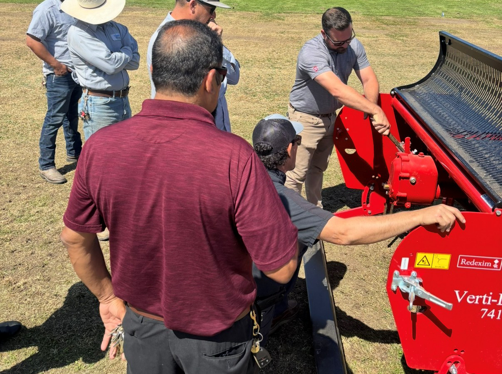Cal Turf team member with a Redexim Verti-Drain on a sports field
